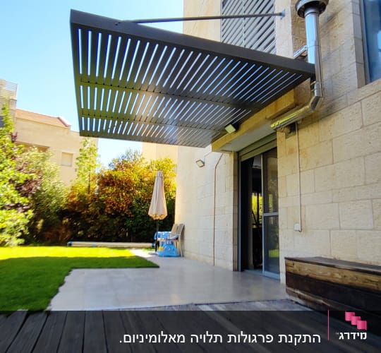 פרגולה מאלומיניום מחוברת לקיר חיצוני של בית